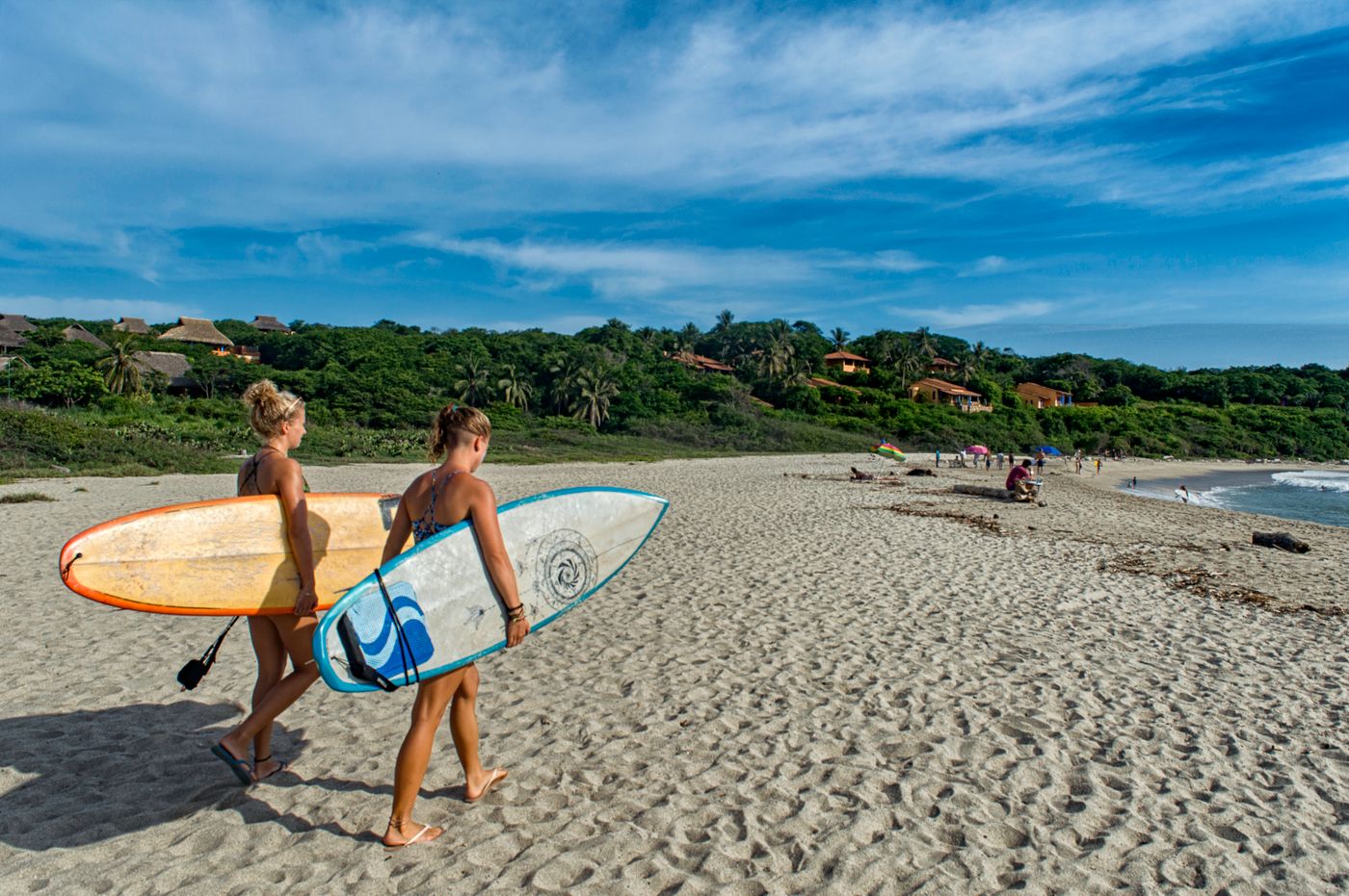 Surfistas caminando con sus tablas en la playa de Puerto Escondido.